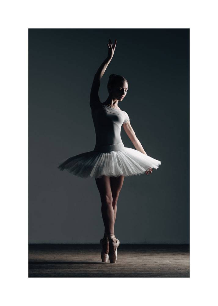 Plakat przedstawiający tańczącą baletnicę w białej sukni na ciemnym tle.