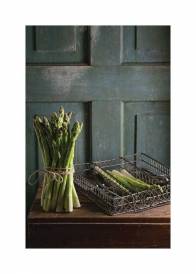 Plakat przedstawiający zielone szparagi w kuchni na tle rustykalnej ściany.