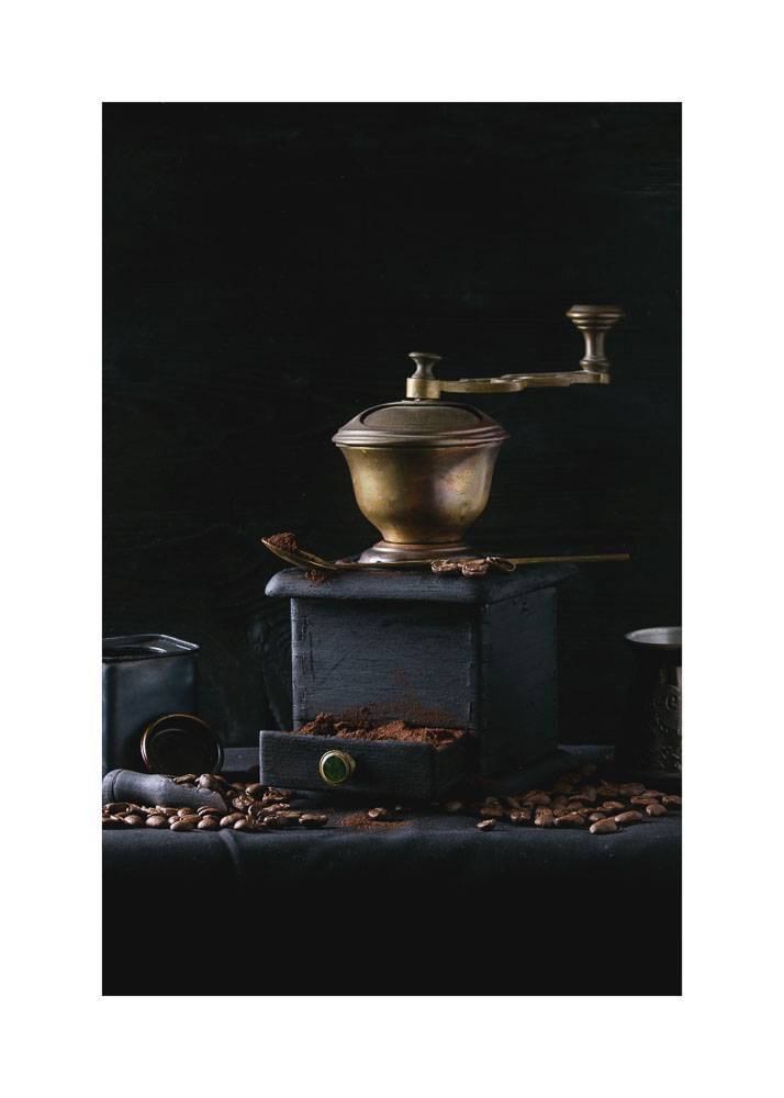 Plakat przedstawiający stary młynek do kawy na czarnym tle.