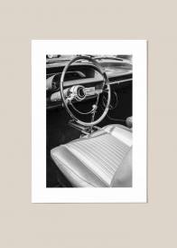 Czarno-biały pionowy plakat przedstawiający wnętrze samochodu retro.