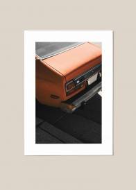 Plakat przedstawiający tył pomarańczowego samochodu.