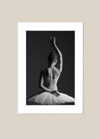 Pionowy plakat przedstawiający tył baletnicy tańczącej w białej sukni ukazany na beżowym tle.