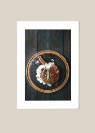 Plakat kuchenny przedstawiający steak z rozmarynem  na drewnianym talerzu na tle drewnianego stołu.