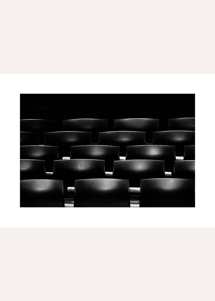 Plakat przedstawiający fotele kinowe w czerni i bieli.