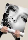 Czarno-biały plakat fotograficzny zwijany w rulon, przedstawiający twarz kobiety z motylem na ustach.