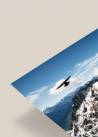 Narożnik plakatu ukazujący ptaka podczas lotu nad górami na tle niebieskiego nieba.