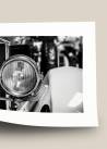 Wywinięty czarno-biały plakat fotograficzny ukazujący lampę samochodu retro.
